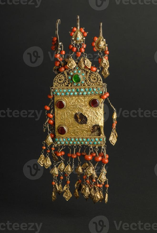 ancient antique pendant with stones on black background. Middle Asian vintage jewelry photo