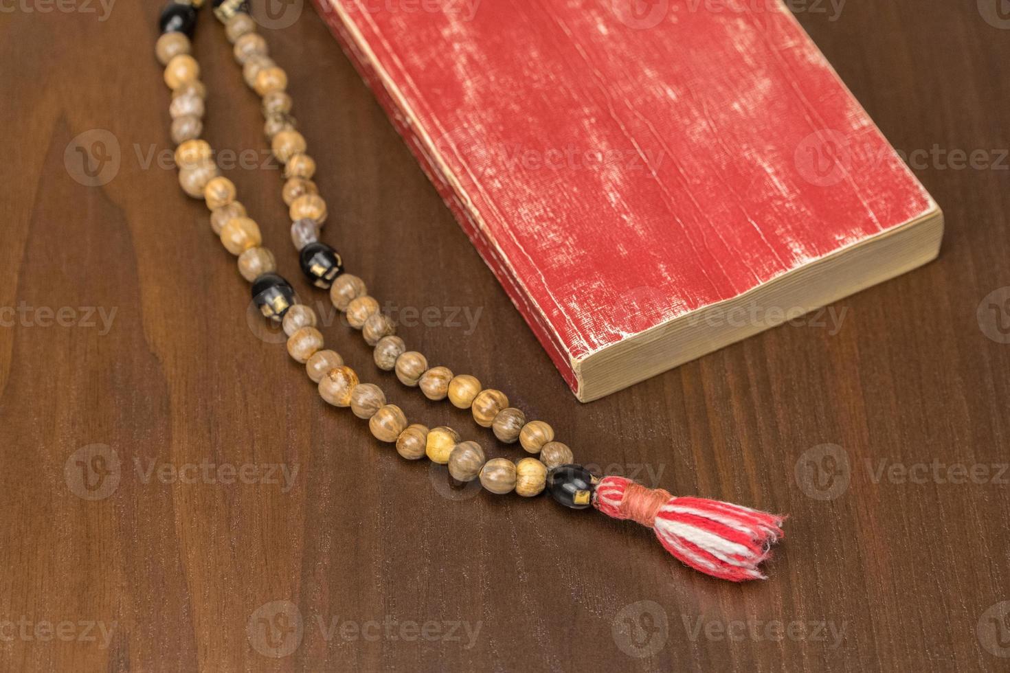 Muslim prayer beads and Quran isolated on a wooden background. Islamic and Muslim concepts photo