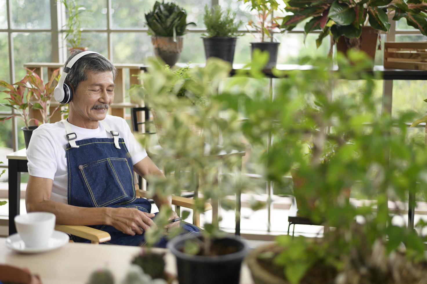 feliz anciano asiático jubilado escuchando música y disfrutando de actividades de ocio en el jardín en casa. foto