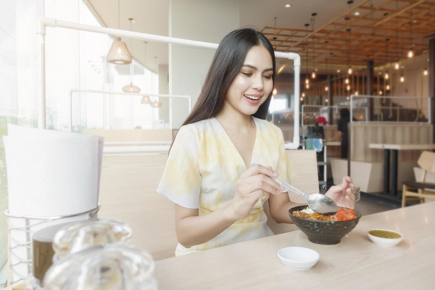 la mujer está comiendo en un restaurante con protocolo de distanciamiento social mientras se encierra la ciudad debido a la pandemia del coronavirus foto