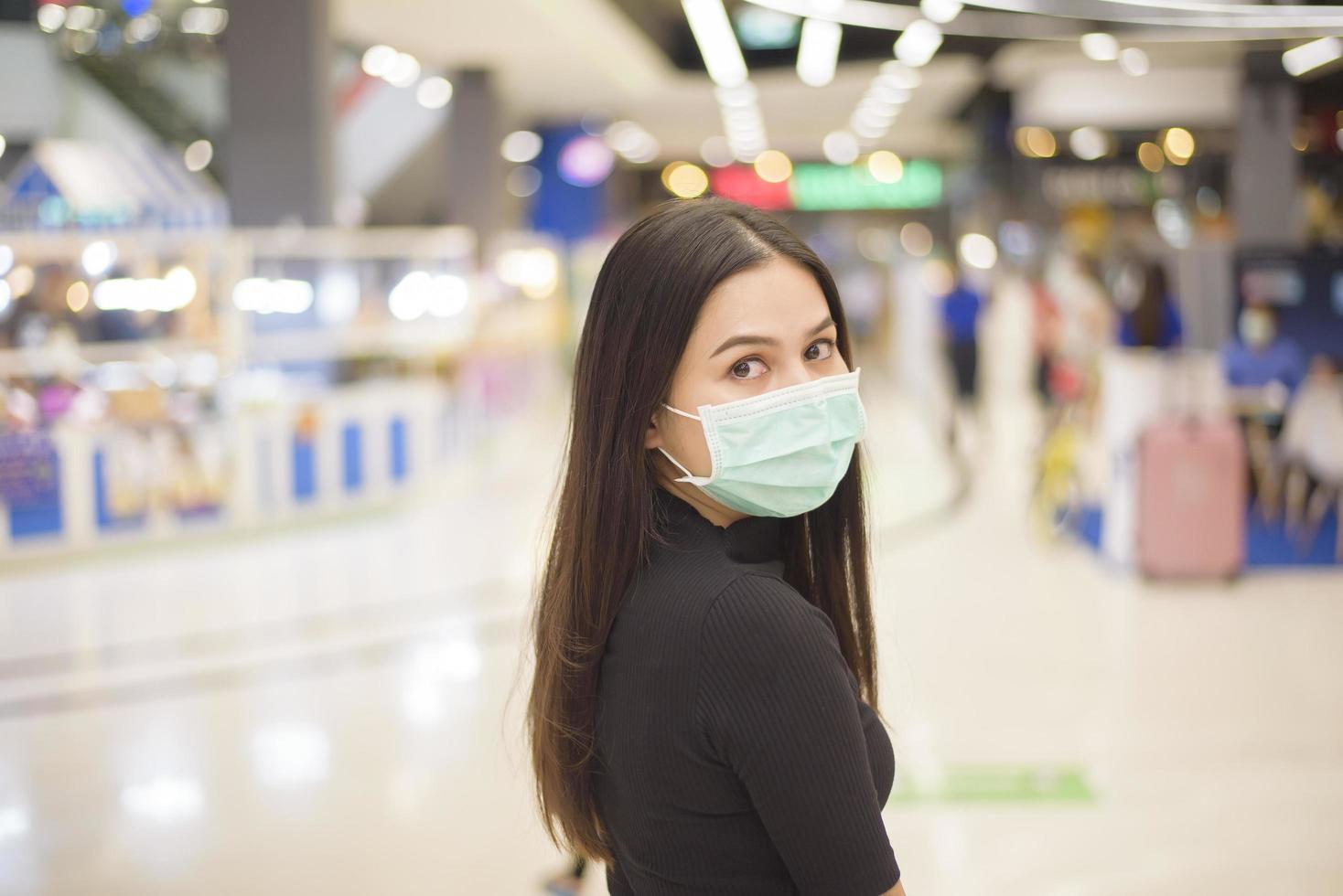 portrait of woman is wearing surgical mask in shopping center photo