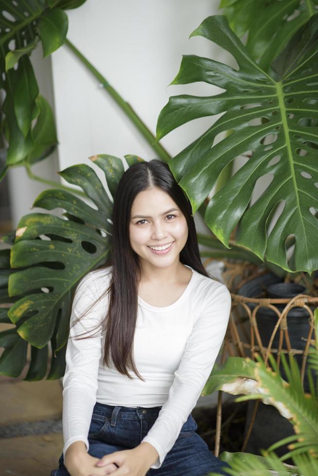 una mujer joven con un retrato de ropa blanca con plantas verdes foto