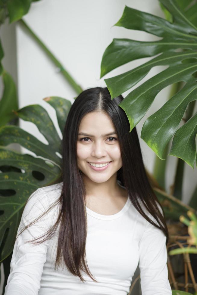 una mujer joven con un retrato de ropa blanca con plantas verdes foto