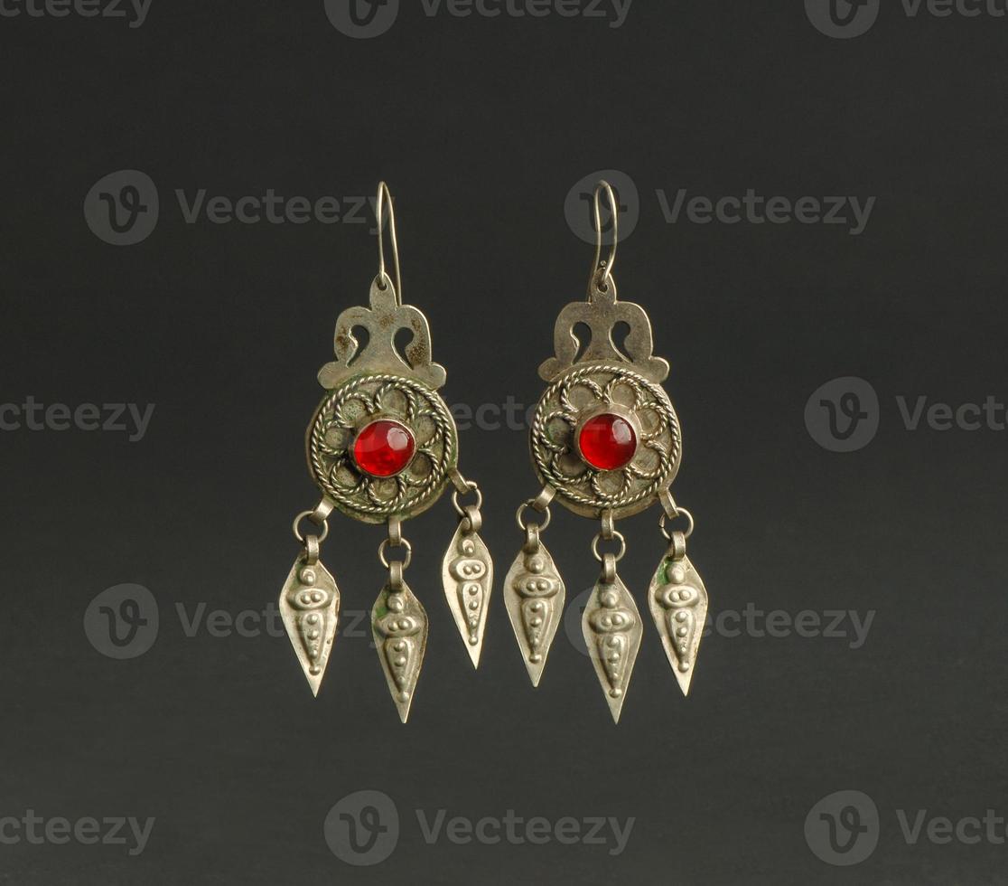 ancient antique earrings with stones on black background. Middle Asian vintage jewelry photo