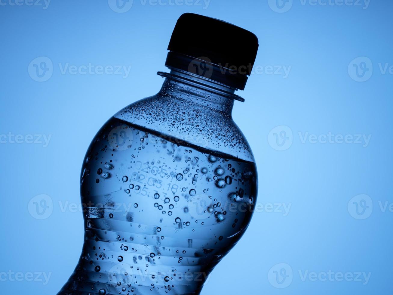 one closed bottle of sparkling water is isolated on a blue background photo