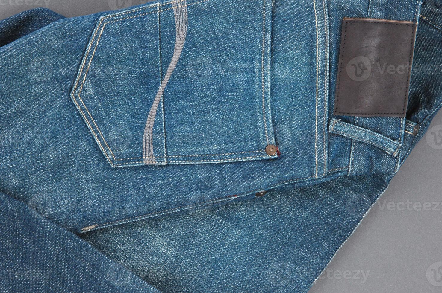 part of denim pants with back pockets and label, closeup photo