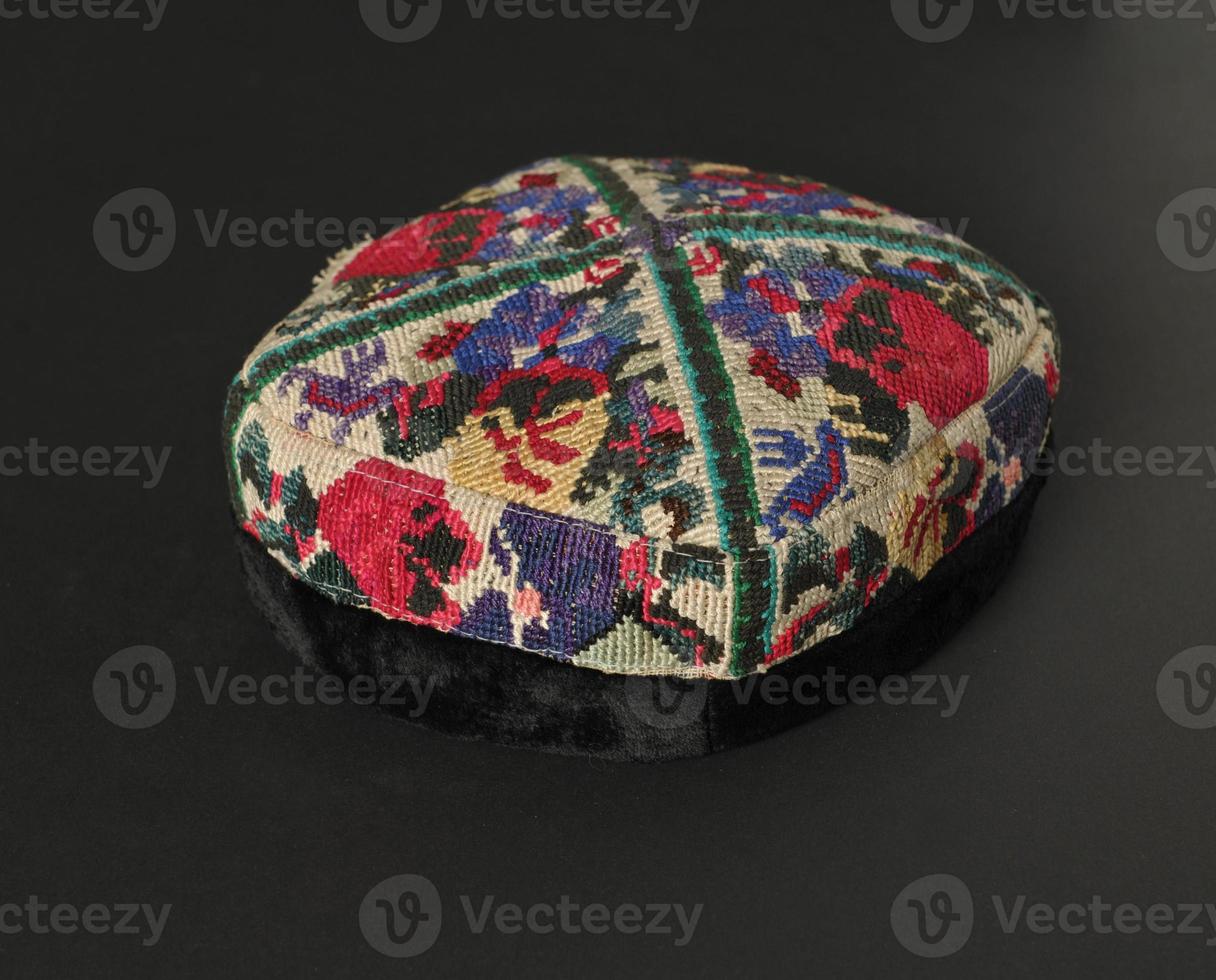 colorful traditional asian skullcap cap on a dark background photo