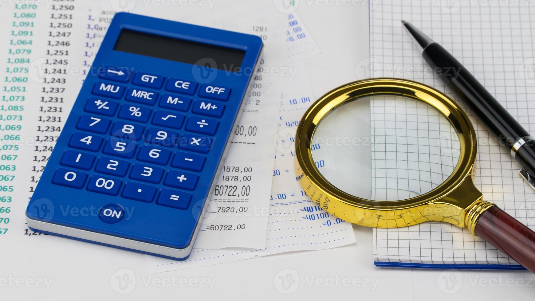 Calculator and magnifier on top of supermarket receipt. Shopping and payment concept photo