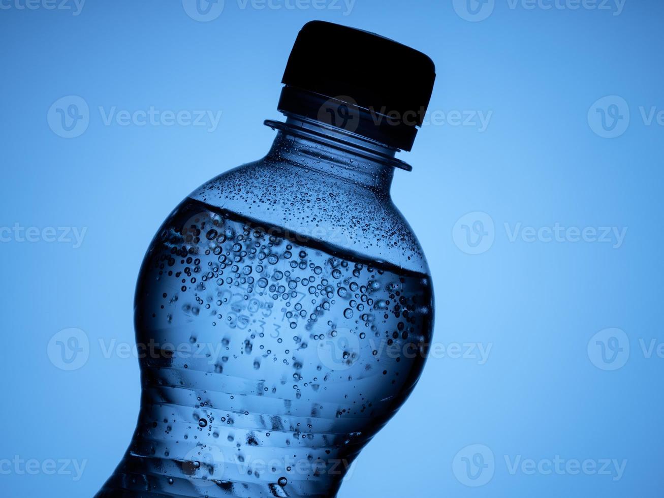 one bottle of sparkling water is isolated on a blue background photo
