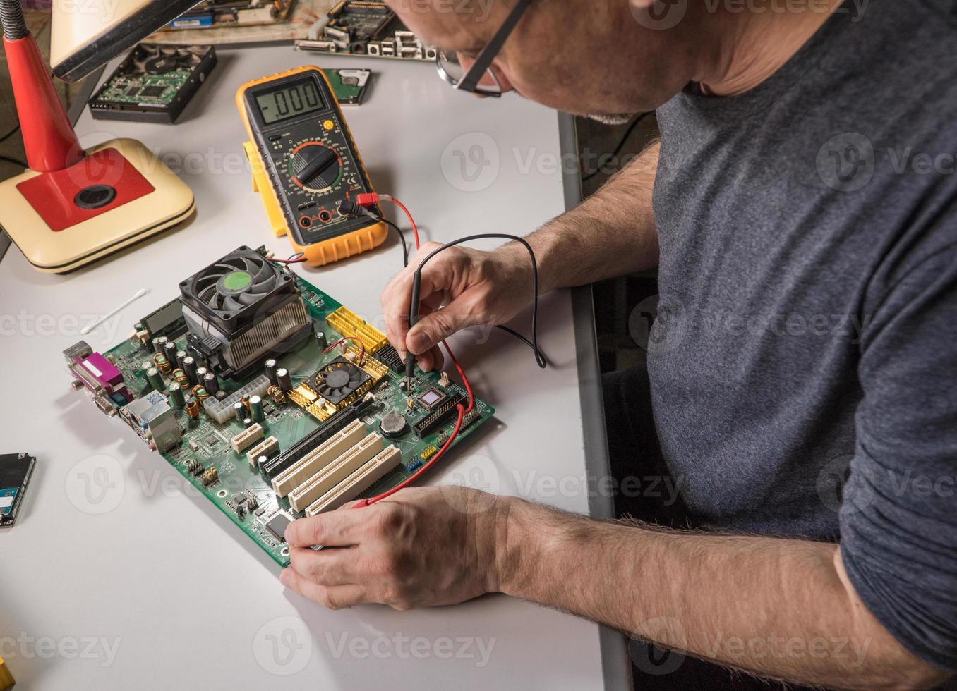 técnico en electrónica está probando un chip de computadora. reparacion de pc foto