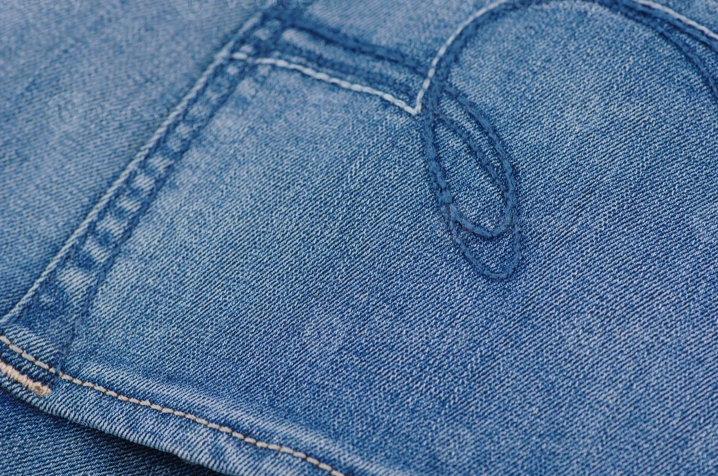 part of the blue denim pants with back pockets, closeup photo