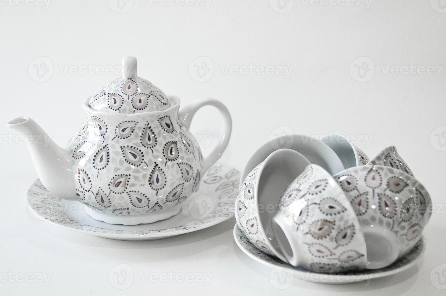 decorated with oriental teapot and bowls on a plate on a white background photo