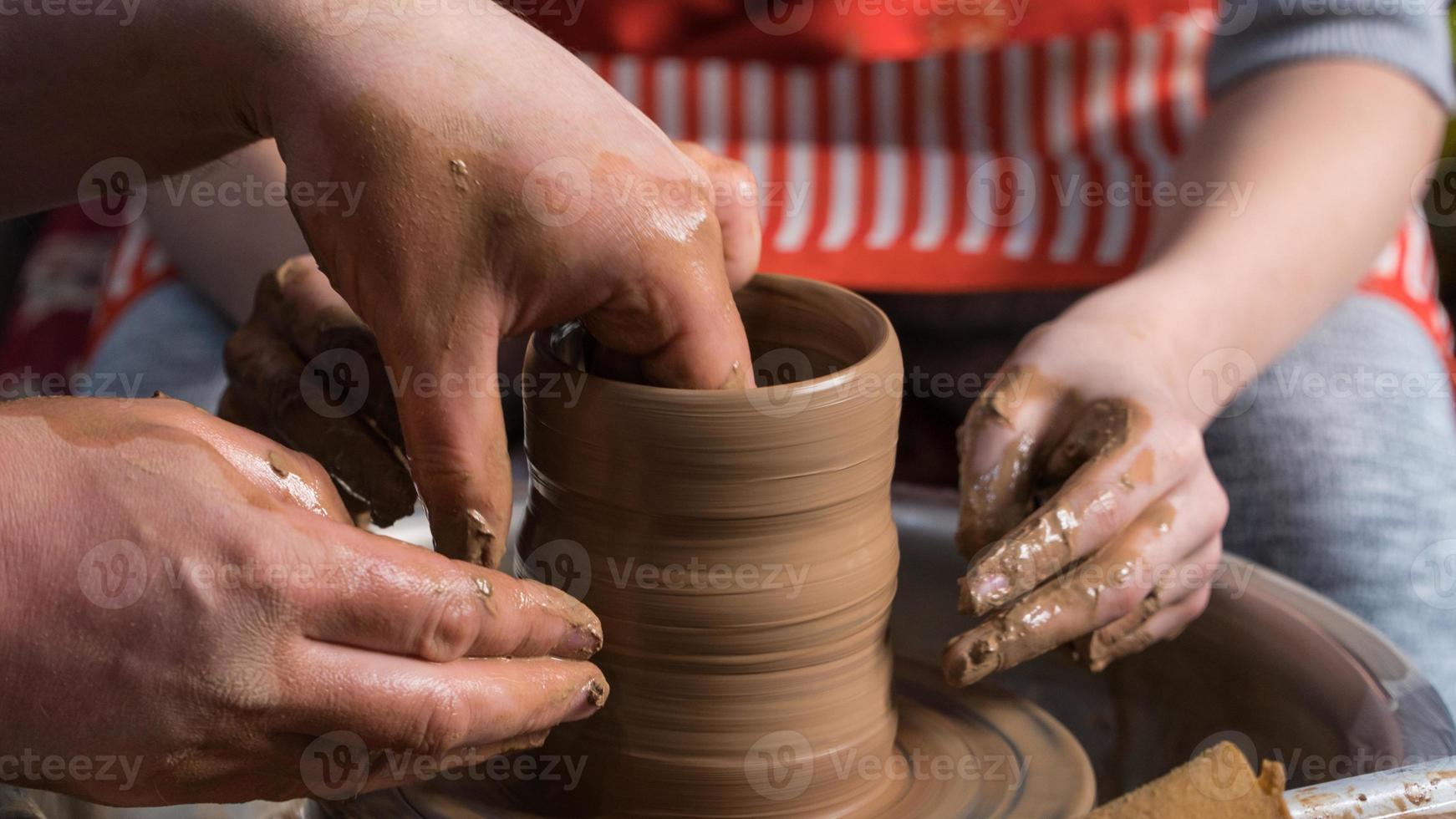 Teaching pottery to children. The teacher gives a master class in modeling photo