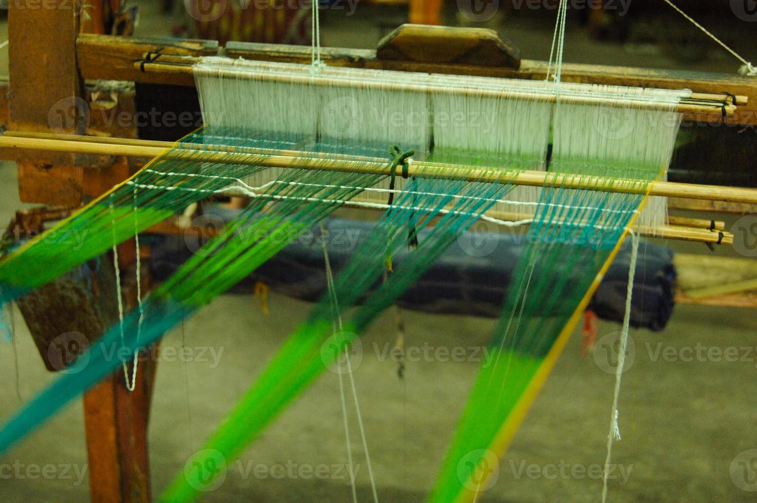 Hand made on a wooden loom manufacture of thread and fabric closeup photo