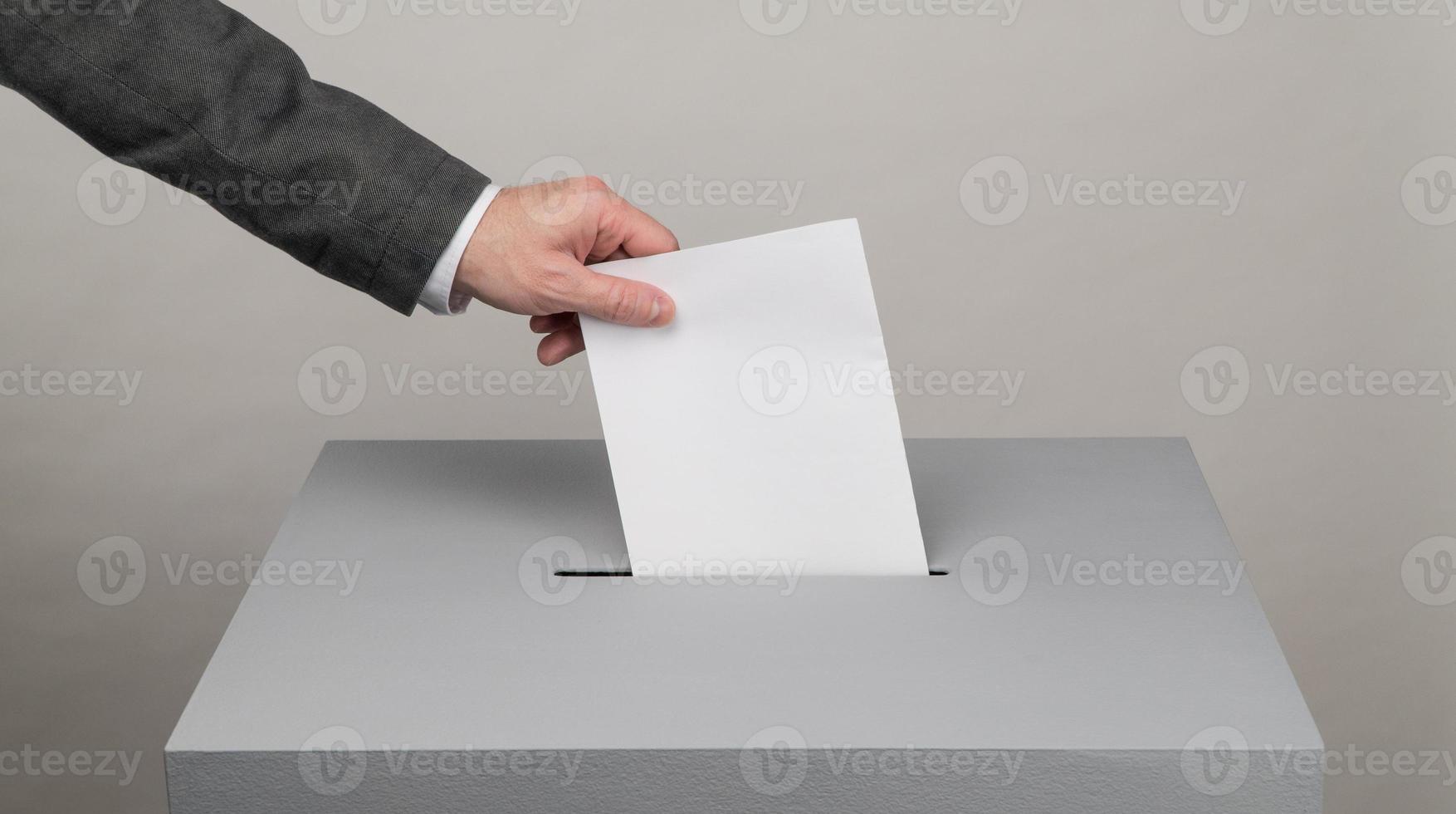 Gray ballot box. Presidential and parliamentary elections. The voter throws the ballot into the ballot box photo