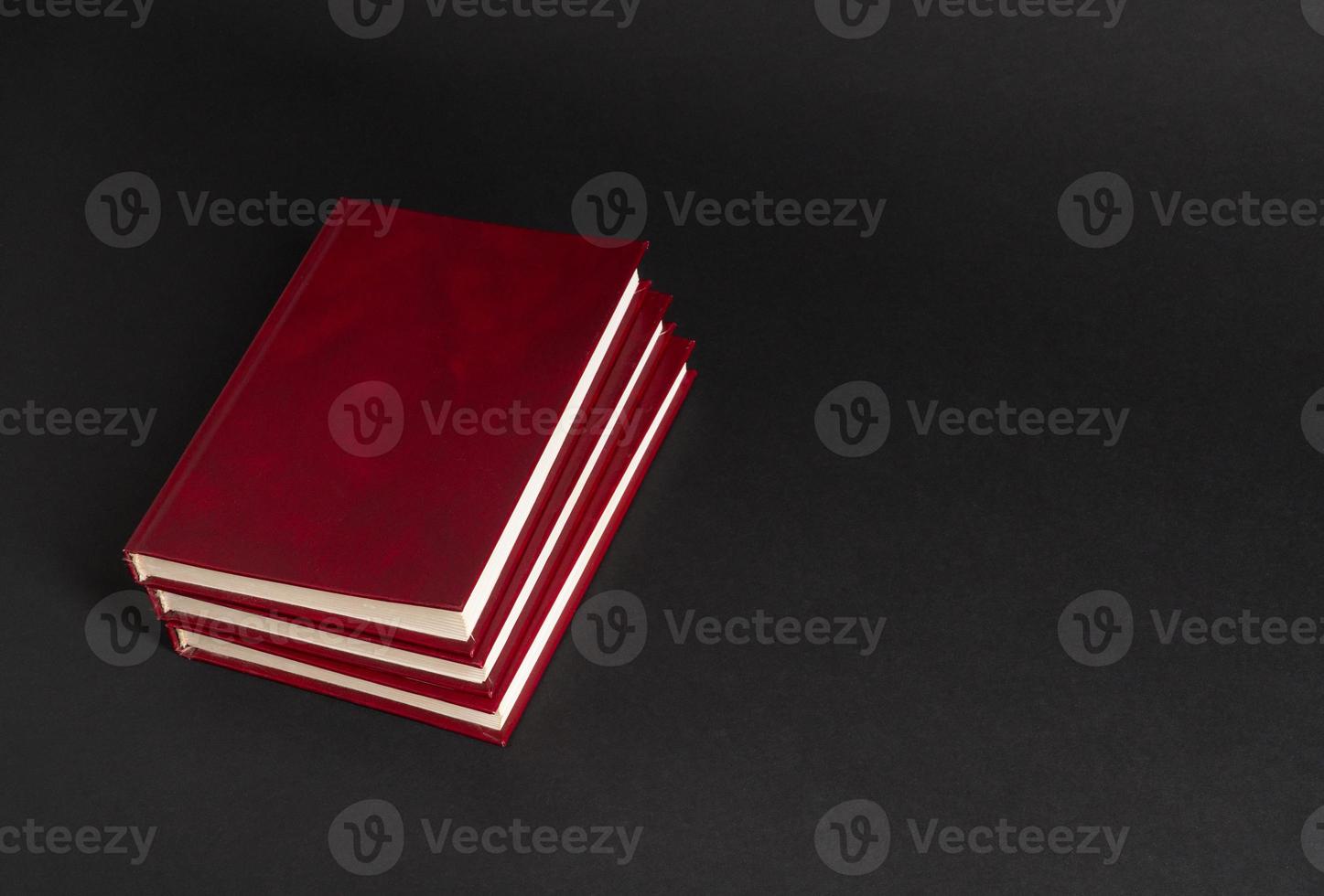 books with red cover on black background, isolated. back to school photo