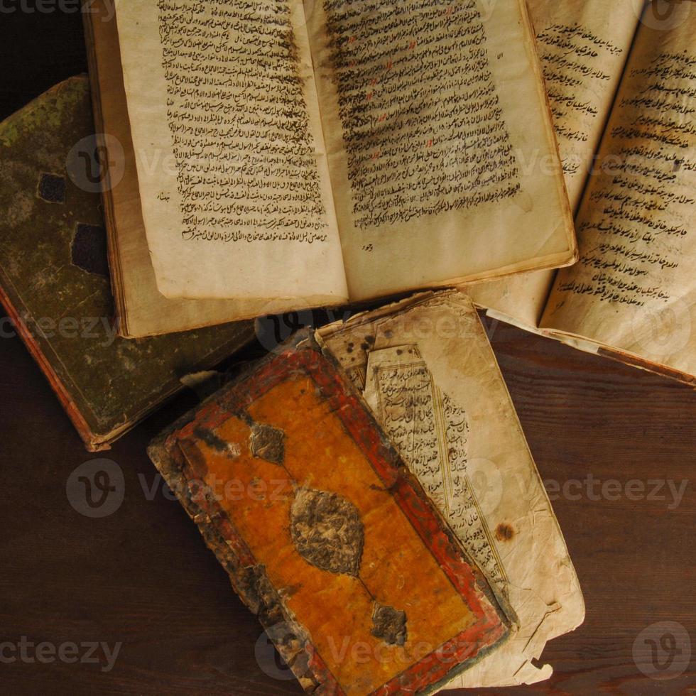 pila de libros antiguos abiertos en árabe. antiguos manuscritos y textos árabes. vista superior foto