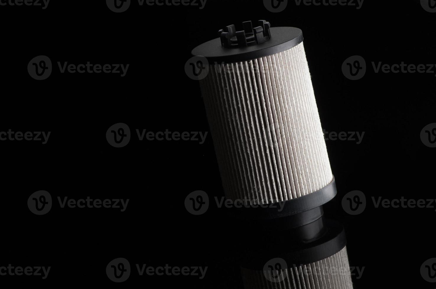 automotive filter cylindrical shape on a black background with reflection photo