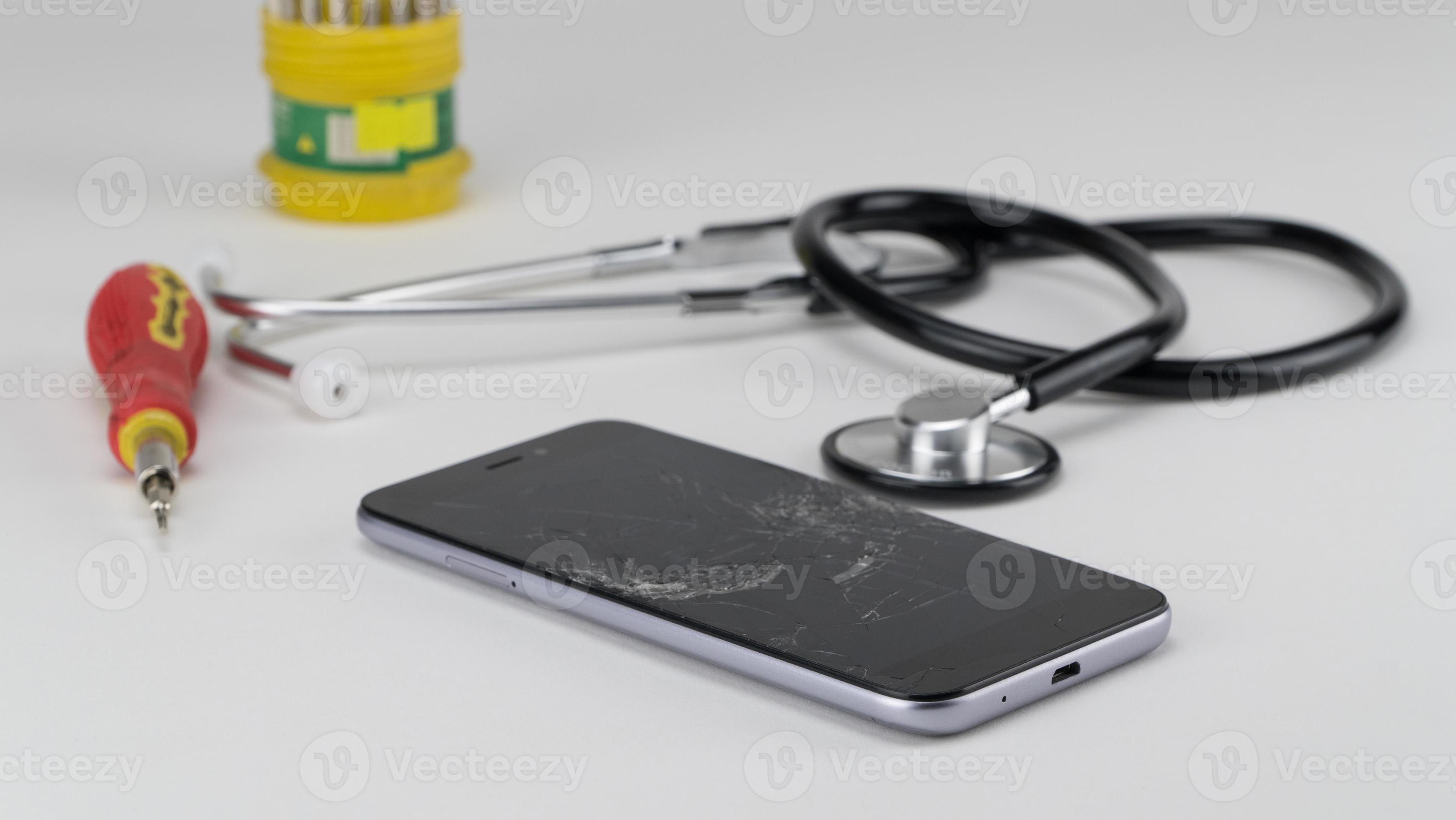 Diagnosing the phone with a stethoscope, near a screwdriver. Phone