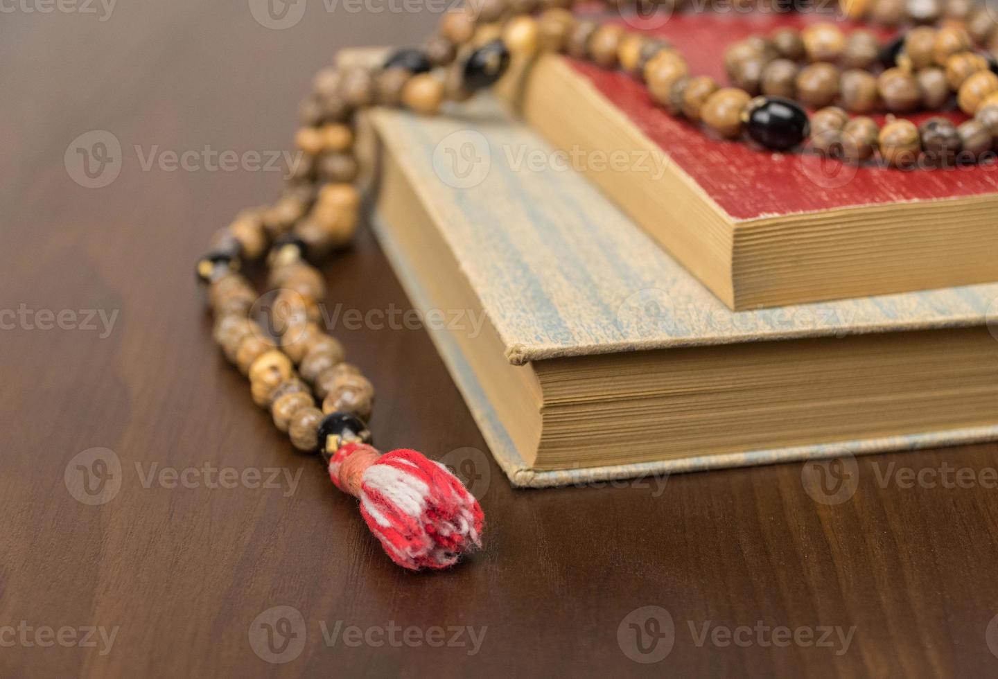 Muslim prayer beads and Quran isolated on a wooden background. Islamic and Muslim concepts photo