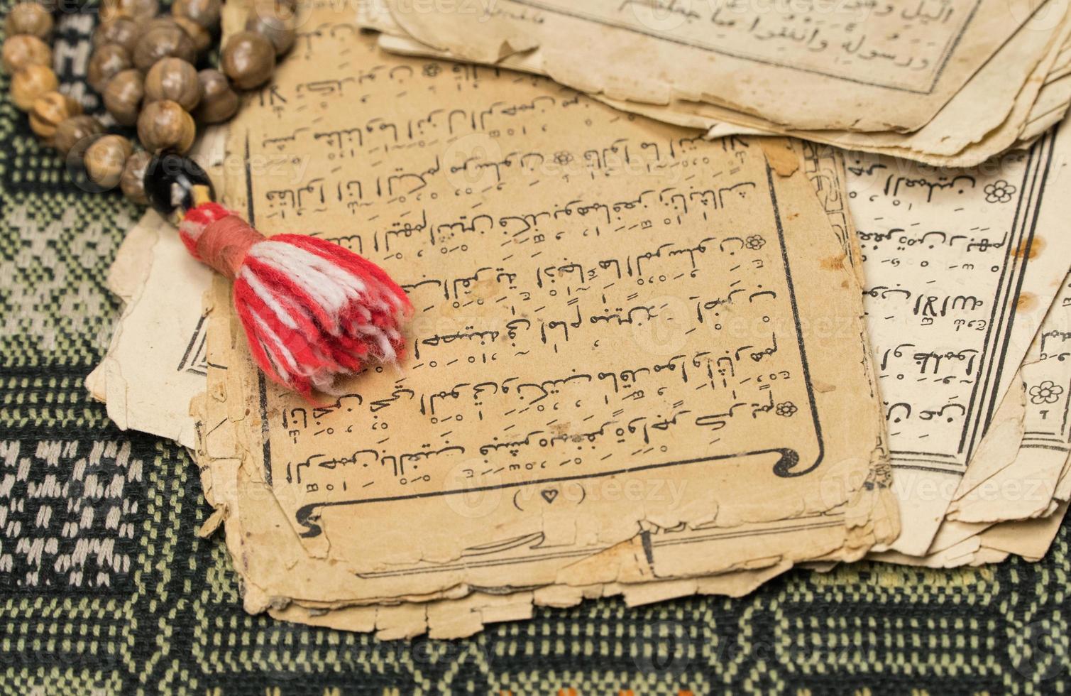 Muslim prayer beads with ancient pages from the Koran. Islamic and Muslim concepts. Ancient old sheets of paper from the Arabic book photo