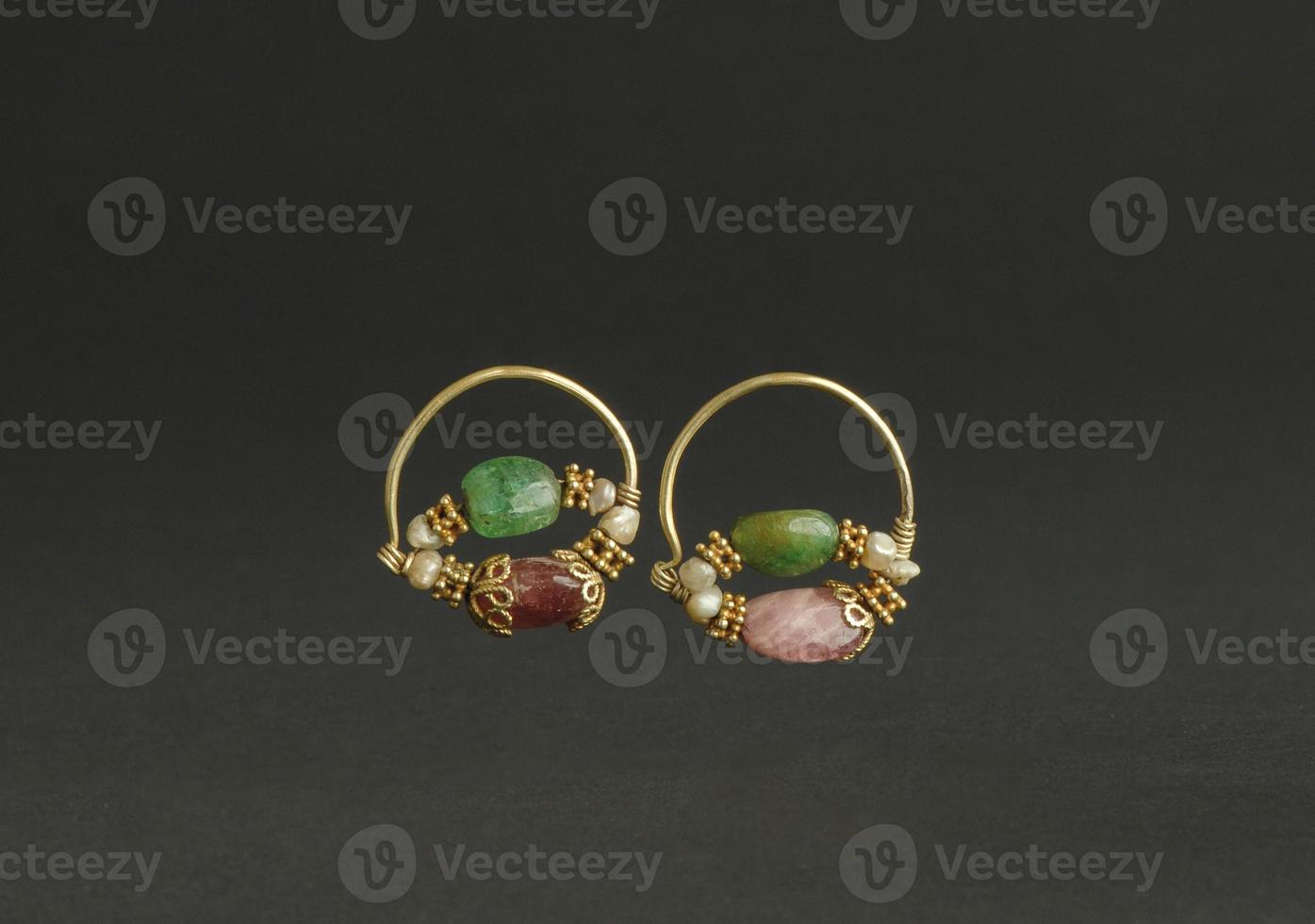 ancient antique earrings with stones on black background. Middle Asian vintage jewelry photo