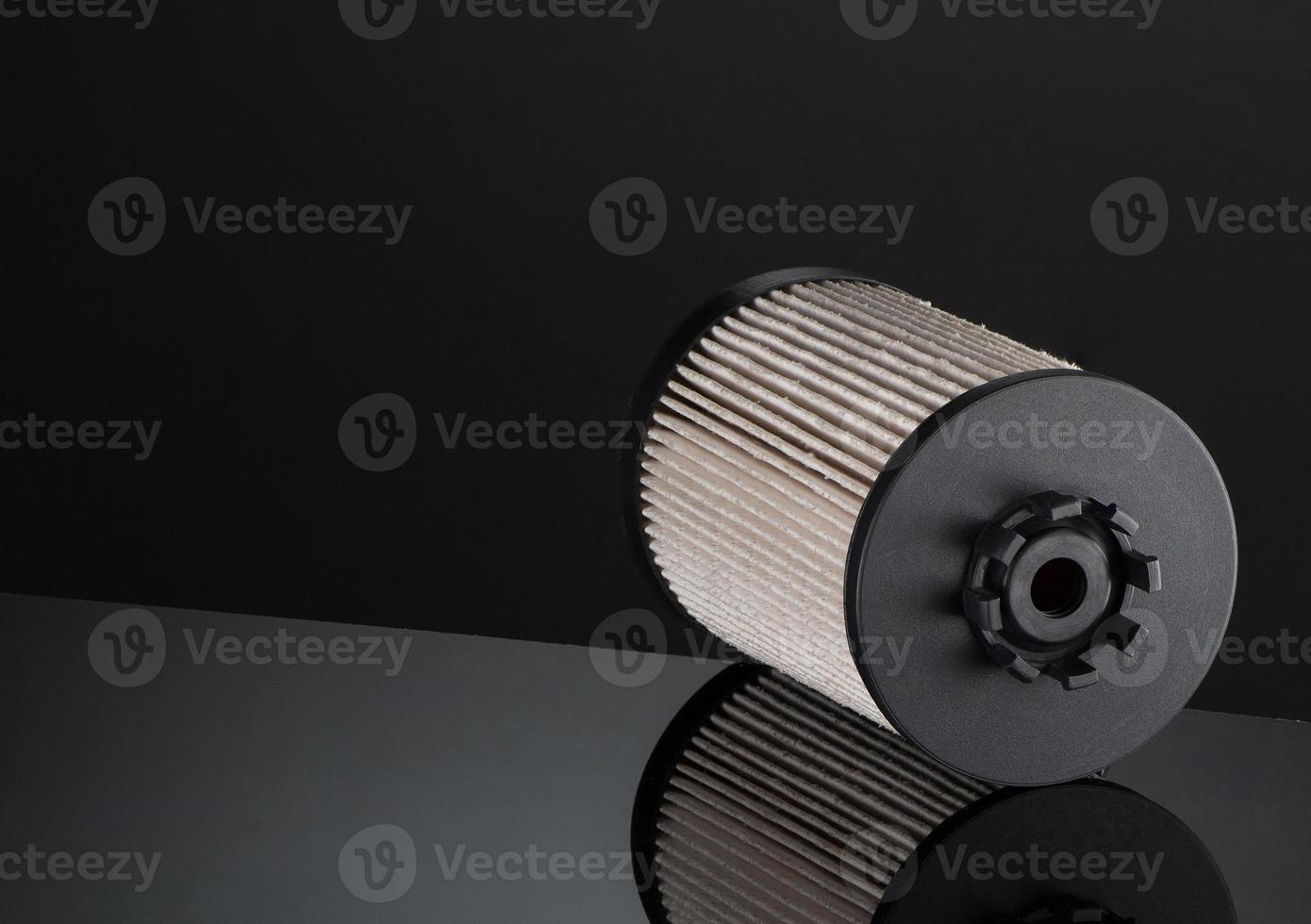 automotive filter cylindrical shape on a black background with reflection photo