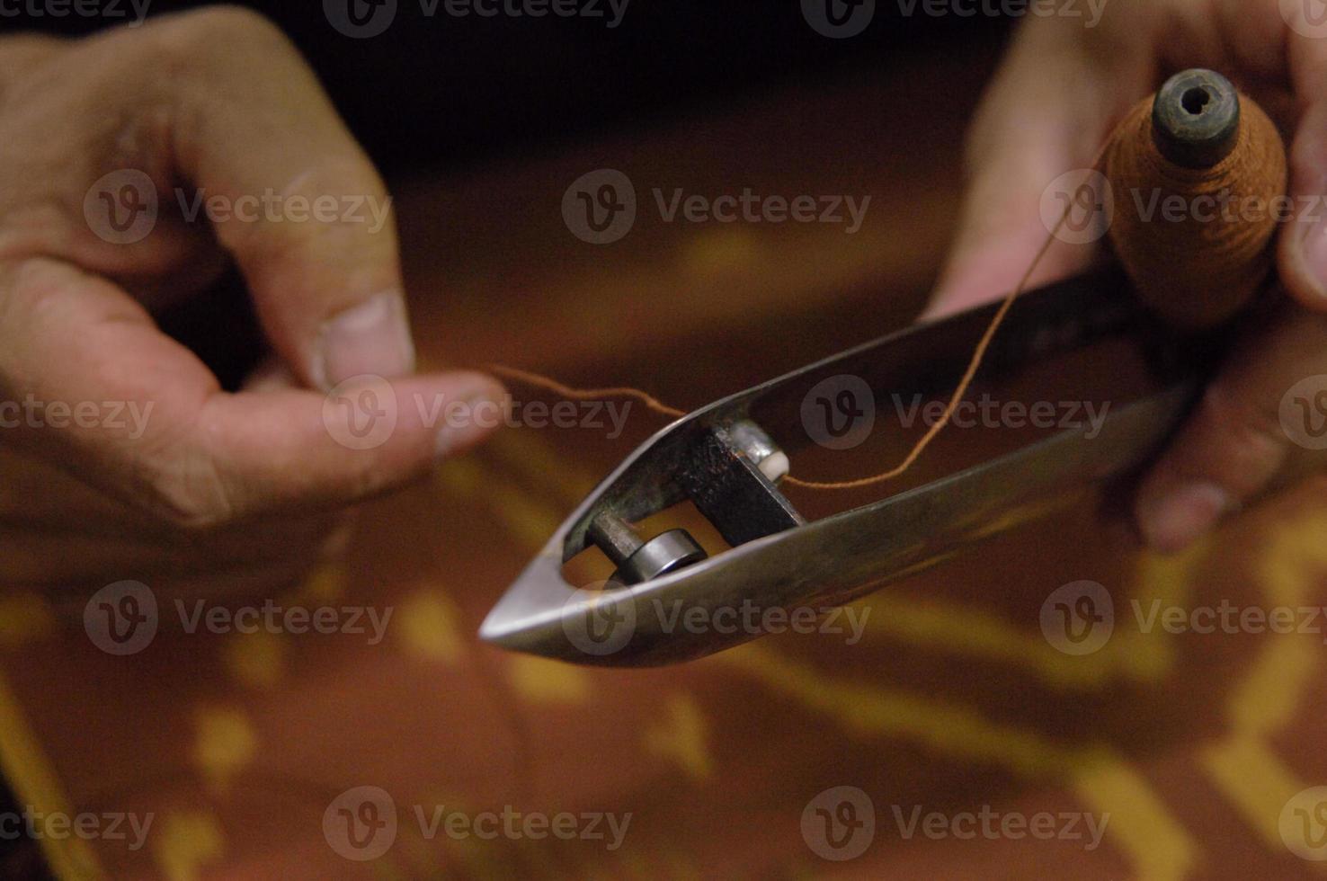 man's hand holding the shuttle loom. photo