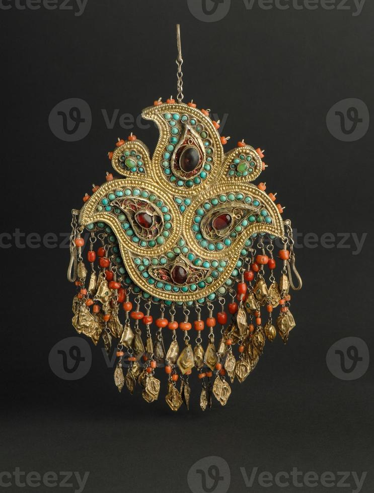 ancient antique pendant with stones on black background. Middle Asian vintage jewelry photo