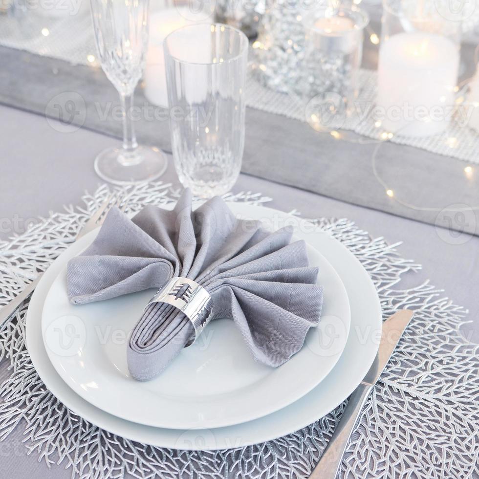 Beautiful table setting with Christmas decorations. Silver colors photo