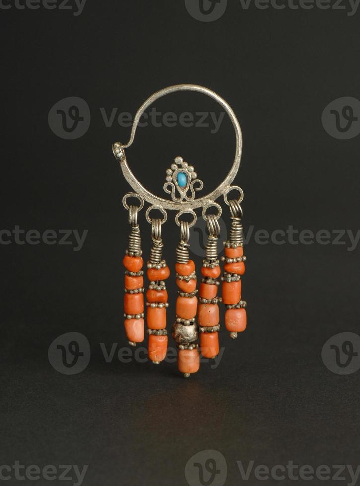 ancient antique earrings with stones on black background. Middle Asian vintage jewelry photo