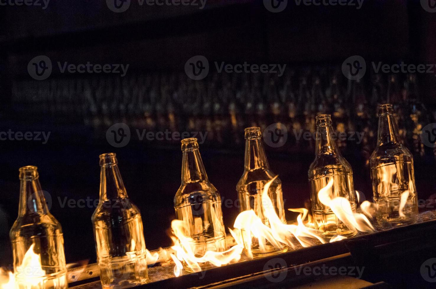 plant for the production of glass bottles. glass bottles on a conveyor belt with fire photo