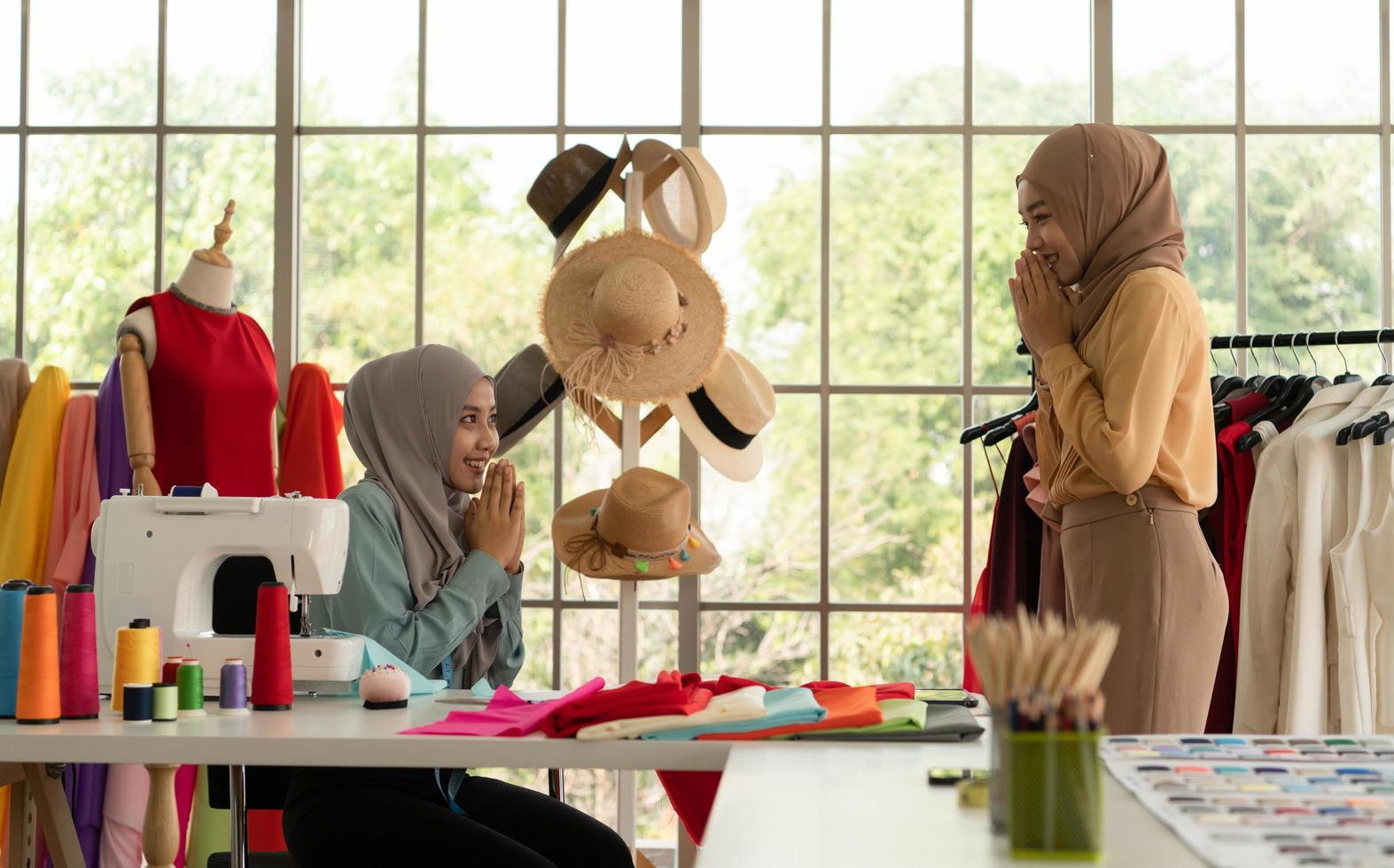 ambas mujeres musulmanas tienen un pequeño negocio en sus propios hogares. es el diseño y confección de ropa. foto