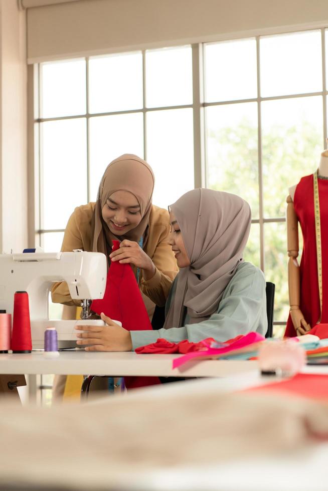 Both Muslim women run a small business in their own homes. Is the design and tailoring of clothes. photo