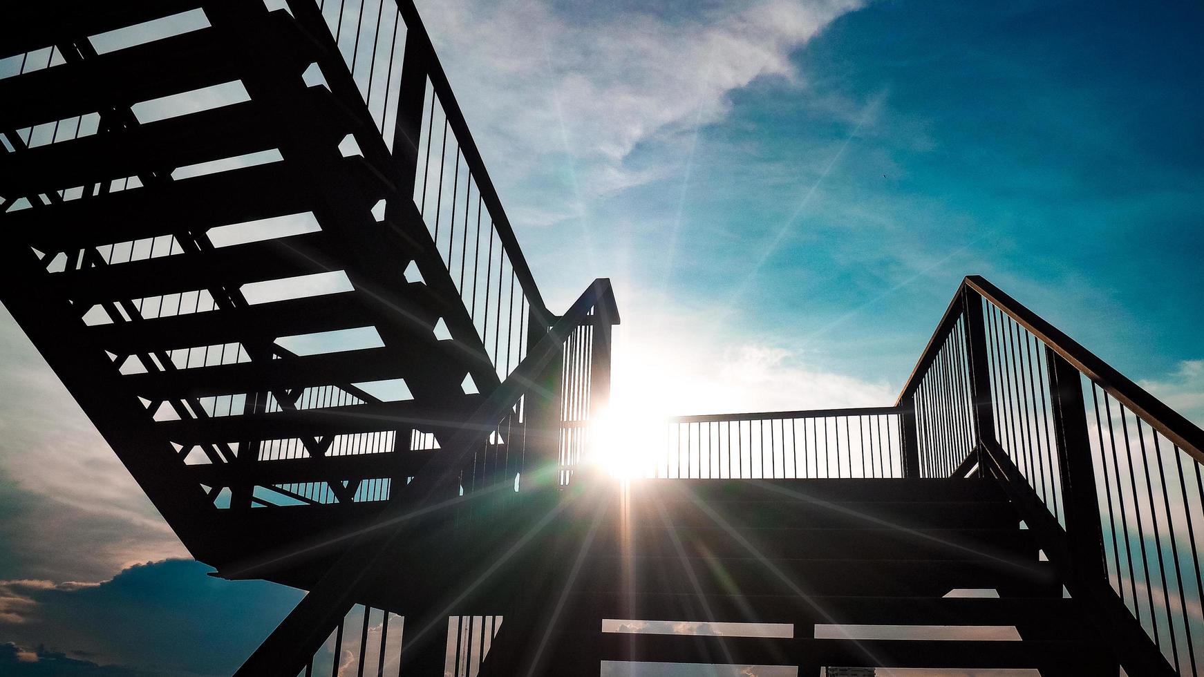 escalera de hierro al aire libre construcción de arquitectura de estructura de acero de color negro sobre la luz del sol con un hermoso fondo de cielo azul foto