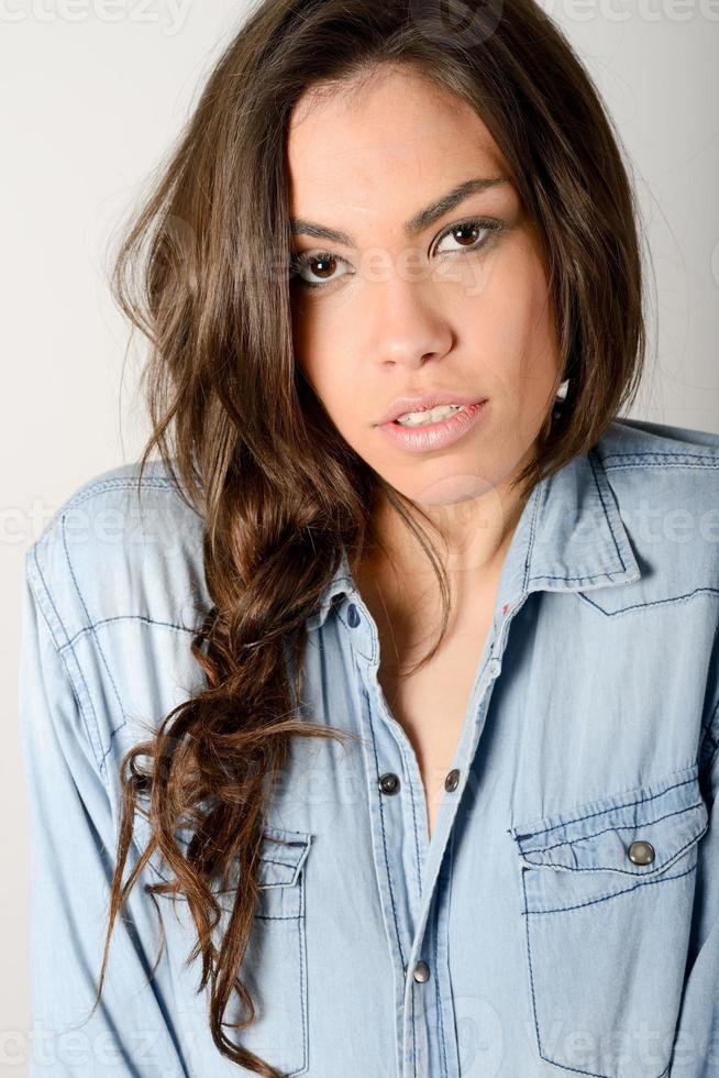 Young casual woman style over gray background. Studio portrait photo