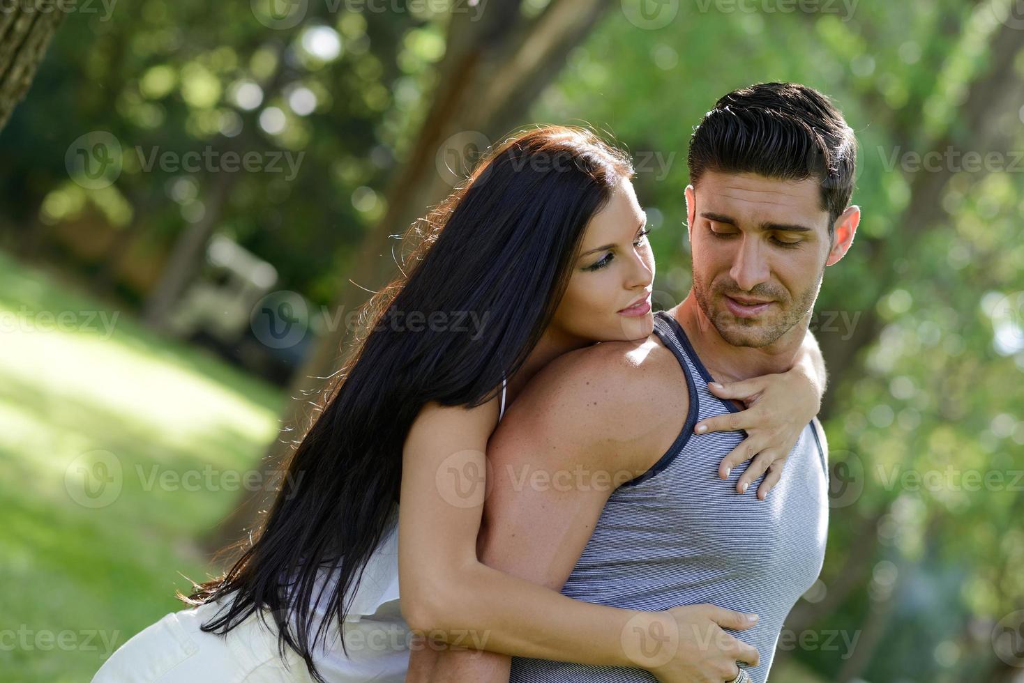 Happy smiling couple laying on green grass photo