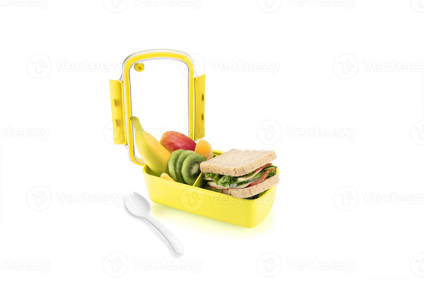 Healthy yellow lunch with sandwiches and fruits for kids. Isolated on white background. photo