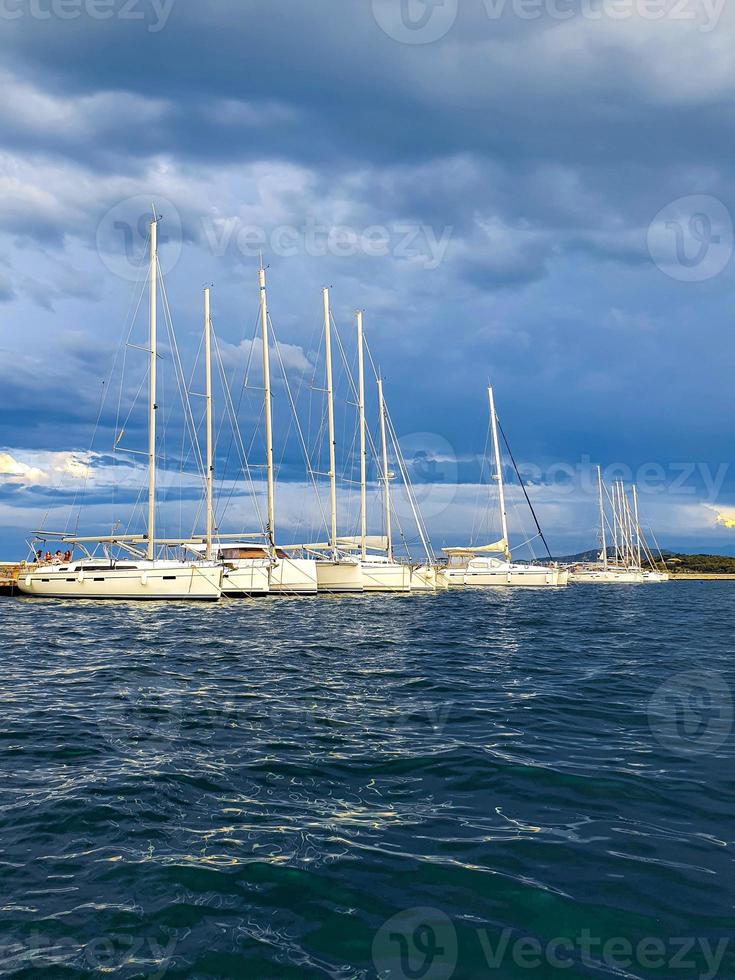 Sailboat harbor, many beautiful moored sail yachts in the sea port, modern water transport, summertime vacation, luxury lifestyle and wealth concept. photo