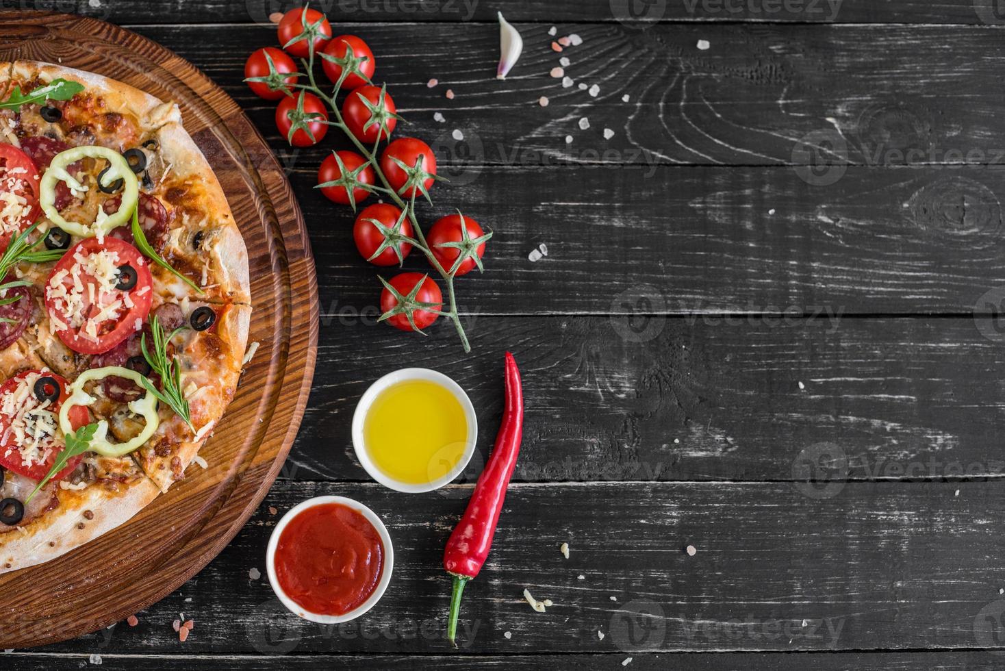 Traditional Italian pizza, vegetables, ingredients on a dark background photo