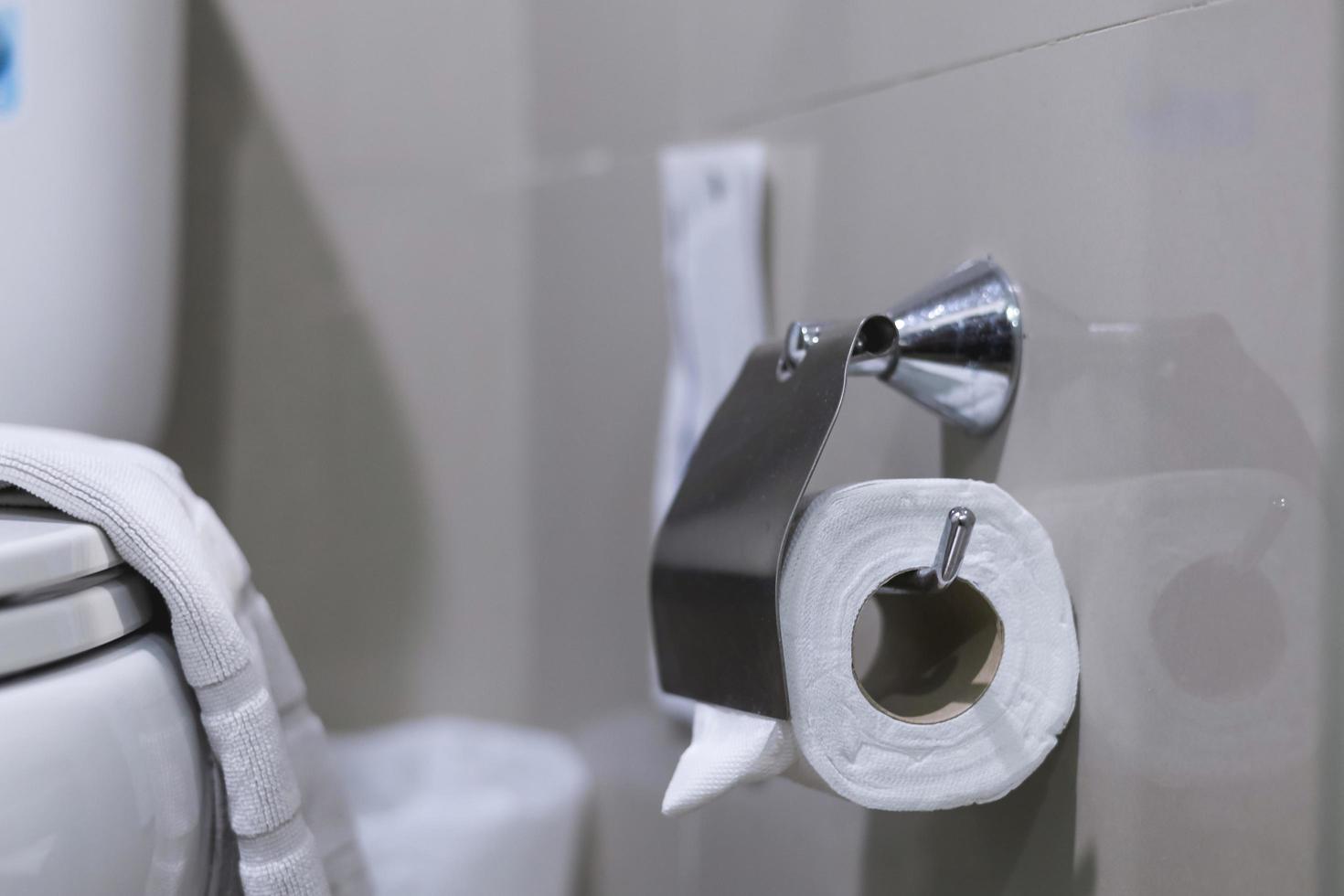 Clean toilet paper in the bathroom. Being folded and being used for the hotel guests photo