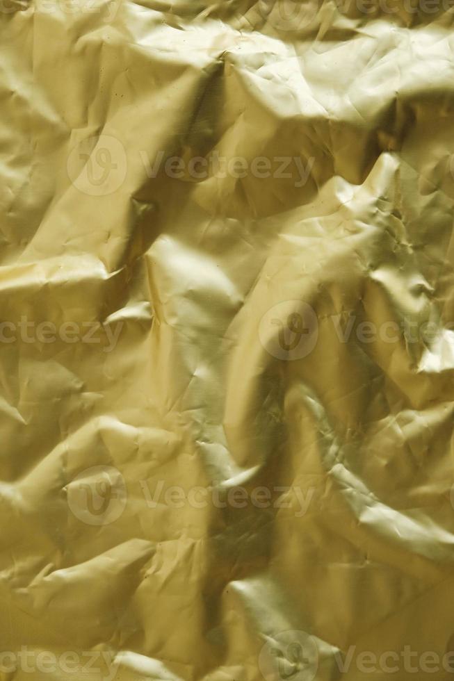 Crumpled gold foil as a background image. Top view. Copy, empty space for text photo
