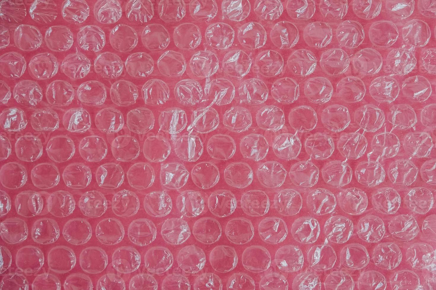 Packaging with air bubbles on a pink background. Bubble wrap texture, packaging, air bubble film. Top view. Copy, empty space for text photo