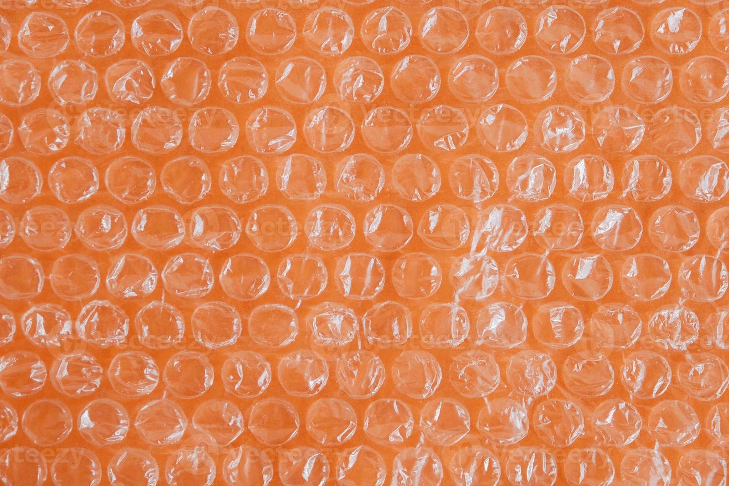 Packaging with air bubbles on a orange background. Bubble wrap texture, packaging, air bubble film. Top view. Copy, empty space for text photo