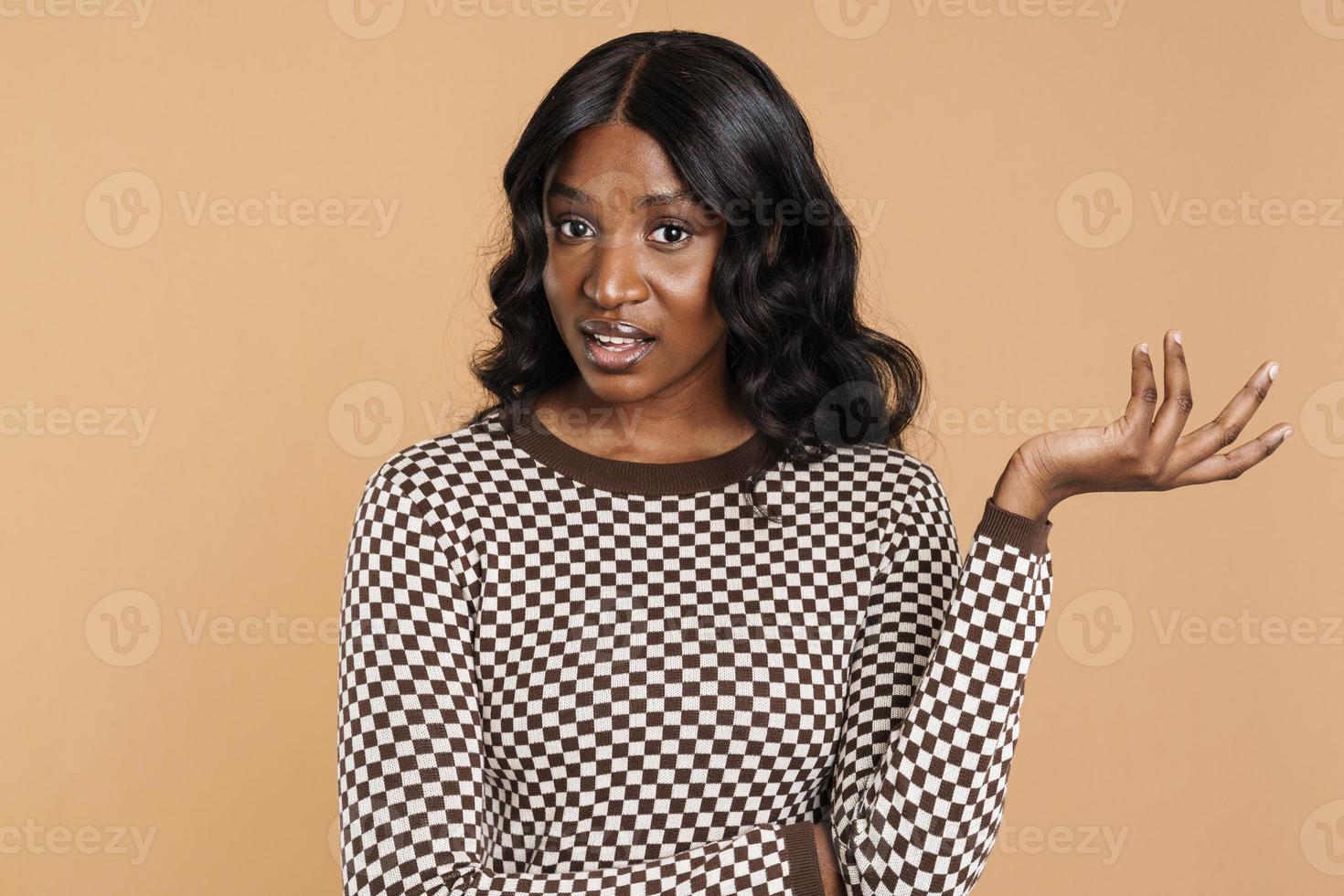 Negatively surprised African woman looking at the camera with hand up photo