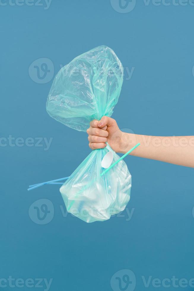 Young woman's arm holding plastic trash bag photo