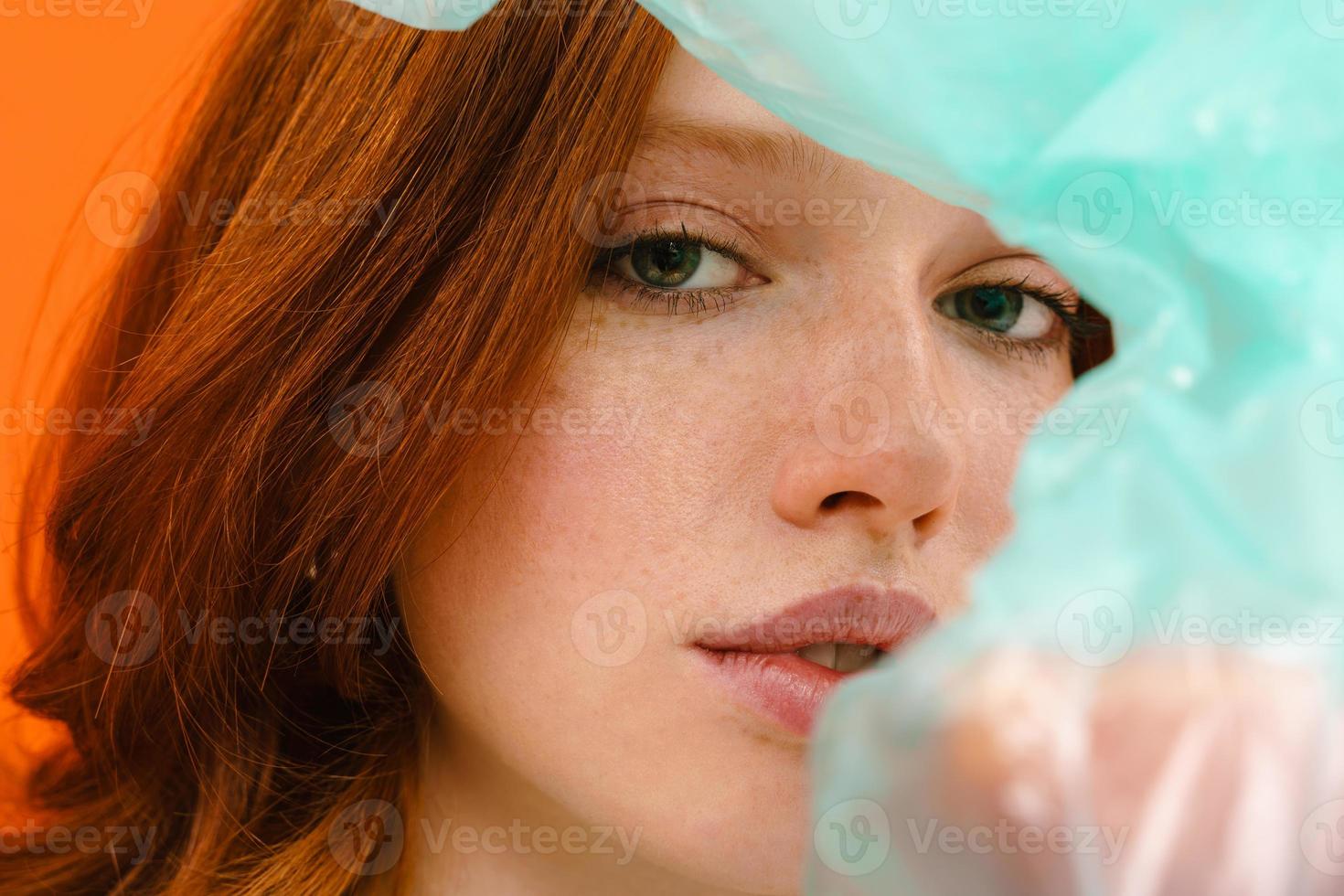 Young ginger-haired woman posing with a plastic trash bag photo