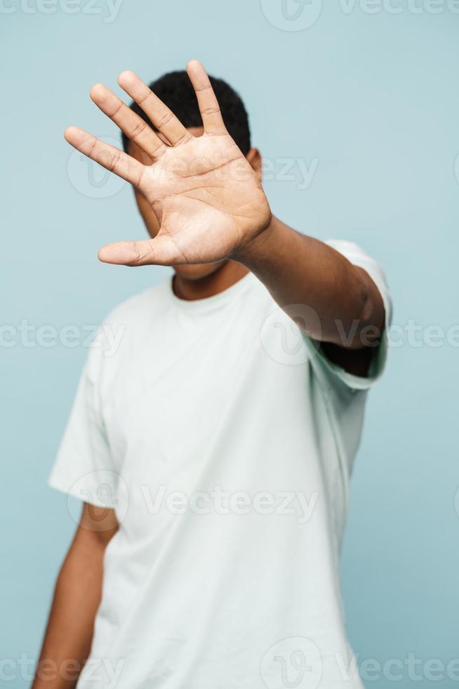 hombre africano que cubre su rostro con la mano foto