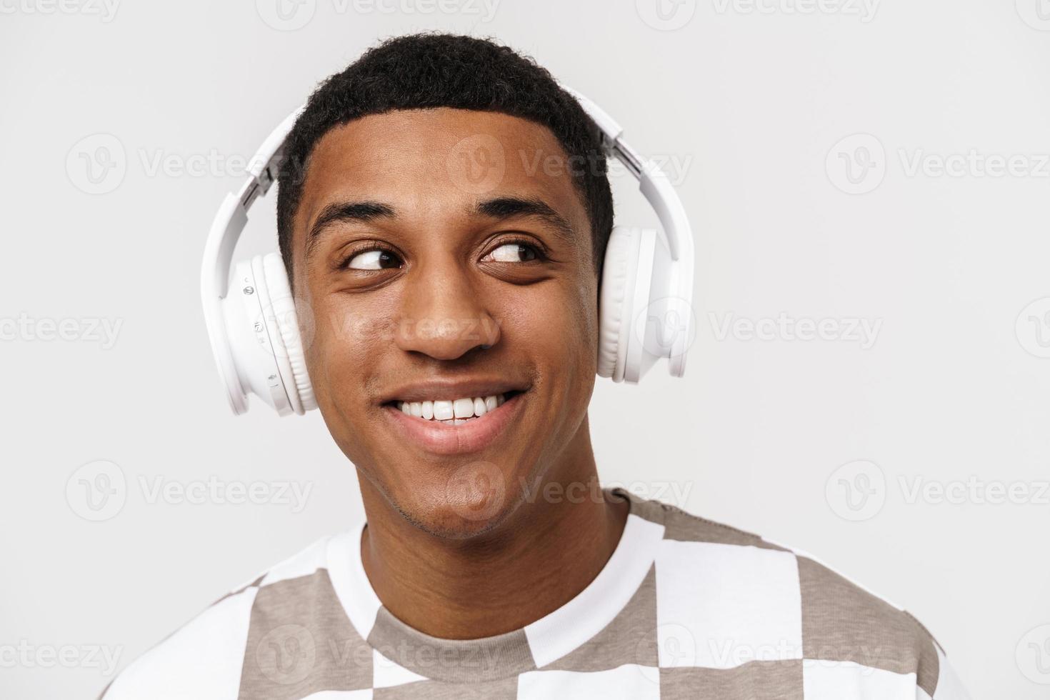 Portrait of positive African man looking to the side with headphones photo