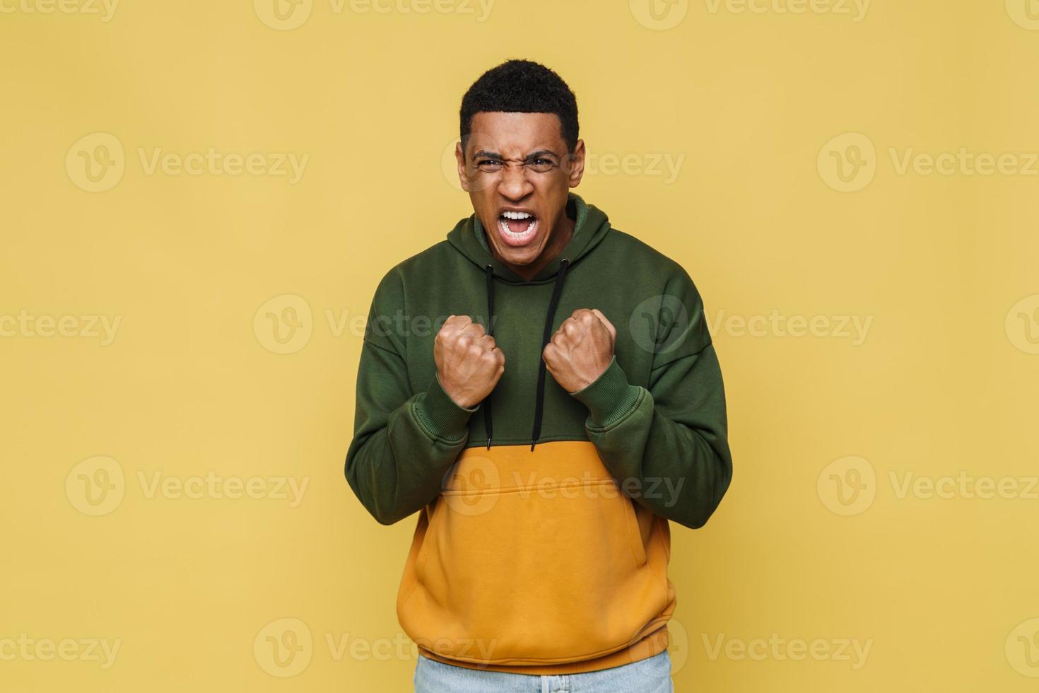 Angry African man in hoodie screaming at the camera photo